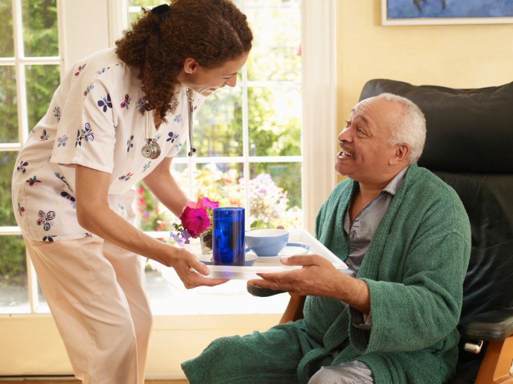 caregiver and senior both smiling