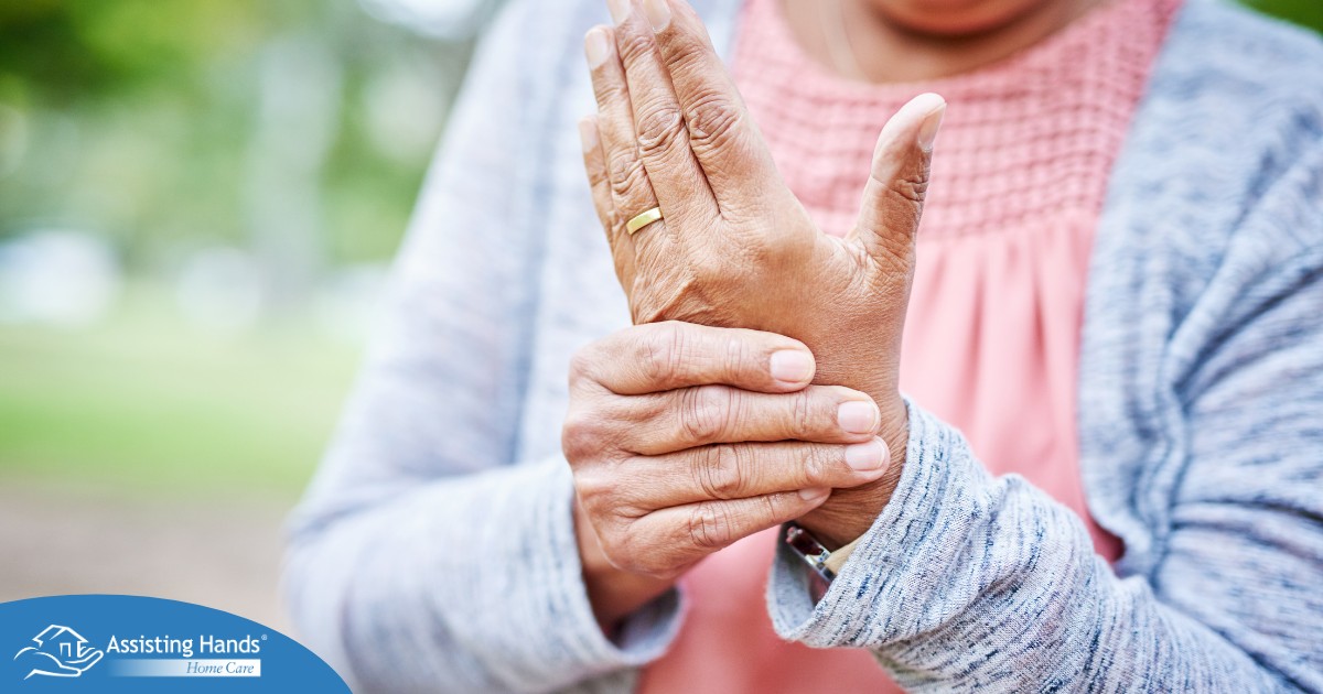 A senior woman holds her hand in pain, representing arthritis and what Arthritis Awareness Month can help with.