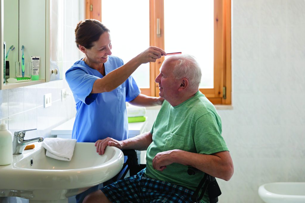 “Caregiver assisting a senior with a seated, safe shower using a handheld sprayer in Davis County, Utah.”