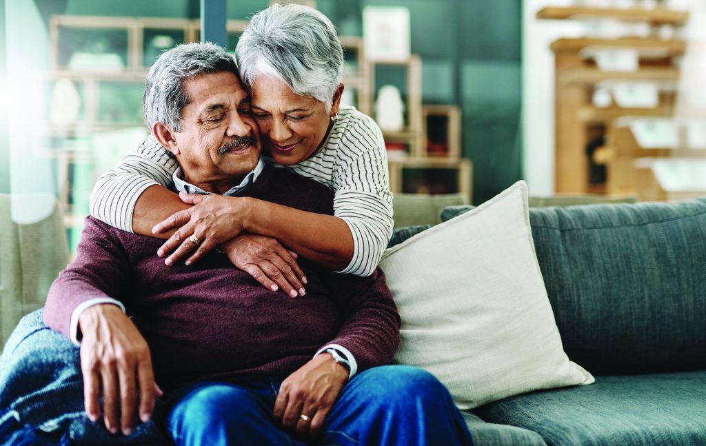 Wife hugging her husband with dementia at home, a family looking into Medicare in-home care