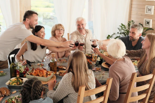Multigenerational family sharing a holiday meal together at the dining table with an elderly parent