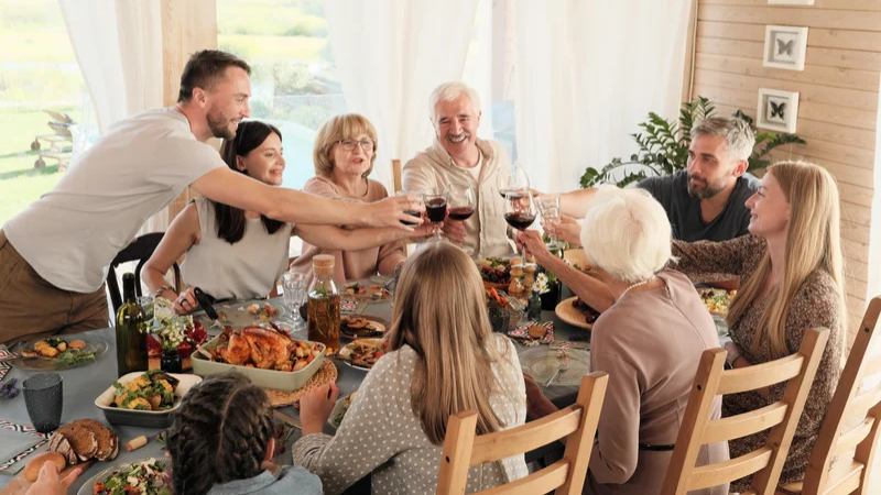 Multigenerational family sharing a holiday meal together at the dining table with an elderly parent