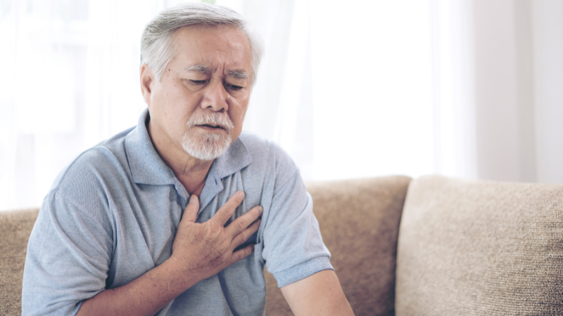 sick elderly man holding his chest