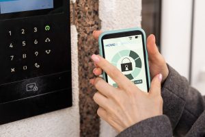 A person uses a smartphone app to control a smart door lock, illustrating one of the key security technologies that supports aging in place home modifications in Murray, UT. These kinds of upgrades give seniors and their families greater peace of mind without requiring a move to a care facility. An aging in place specialist in Murray, UT can help identify which smart home technologies make the most sense for your loved one's specific needs. 