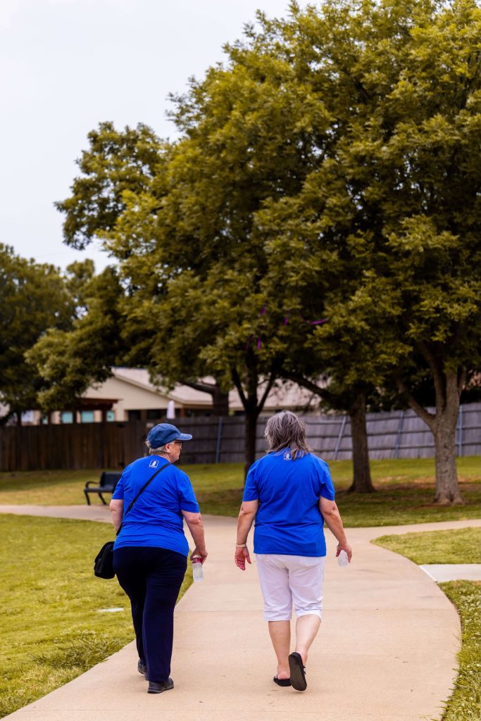 Two women take a walk together outdoors, the kind of guided physical activity that supports fall prevention for seniors in Murray, UT through home care services in Murray, UT and reduces fall risk in Murray, UT.