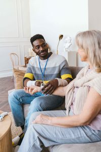 A senior caregiver in Murray, UT gently checks an older woman's blood pressure at home, reflecting the steady, attentive support families rely on. This kind of 24/7 home care and respite care Murray helps prevent caregiver burnout in Murray, UT for family members carrying the load. 
