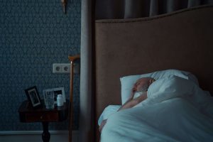 An elderly man sleeps peacefully in a dim bedroom at night, a glass of water and medication resting on the nightstand and a cane within easy reach. Nighttime is when confusion, falls, and wandering are most likely, which is why 24 hour home care matters so much after dark. 24/7 home care and at home caregivers in Murray, UT provide the overnight supervision and reassurance that families can count on while they rest. 