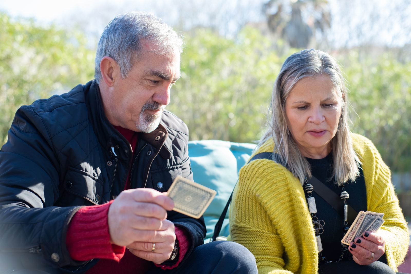 Older adults enjoying a friendly game of cards outdoors