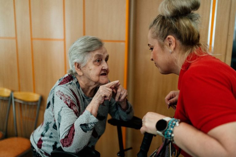 Caregiver and older woman talking together at home