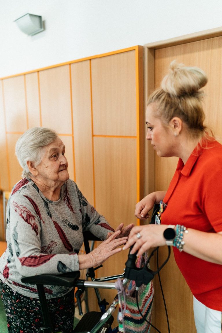 Caregiver helping an older woman walk safely with her walker