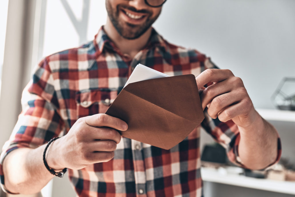 Guy-Opening-Greeting-Card-Smiling