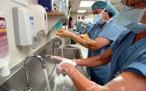 doctors scrubbing up at a metal sink