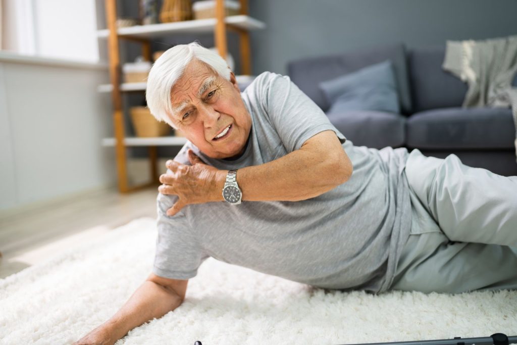 senior man fell in the living room and got hurt on the shoulder
