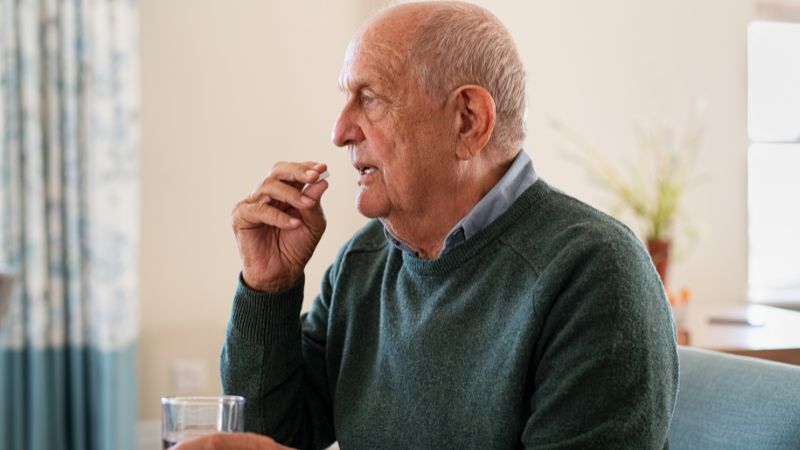 Old Man Taking His Medicine