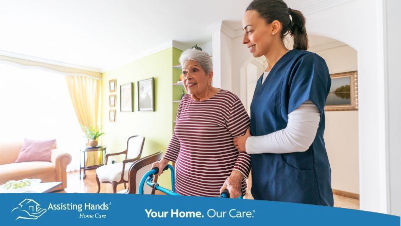 caregiver holding senior woman who has parkinsons and helping her walk