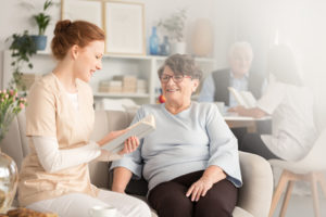 caregiver reading to senior woman