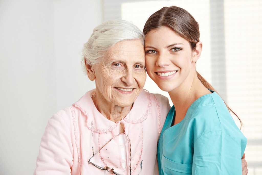 Female Caregiver Hugging a Smiling Female Senior