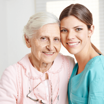 Female Caregiver Hugging a Smiling Female Senior