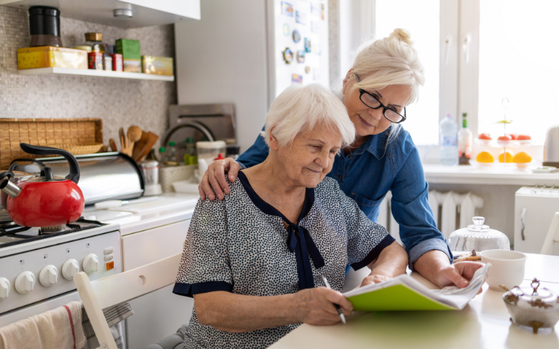 Woman help reviewing finances for their elderly parent