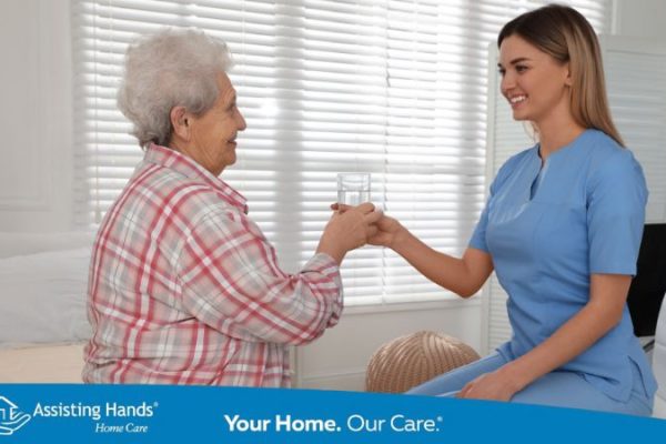caregiver giving water to senior to prevent uti and seizure