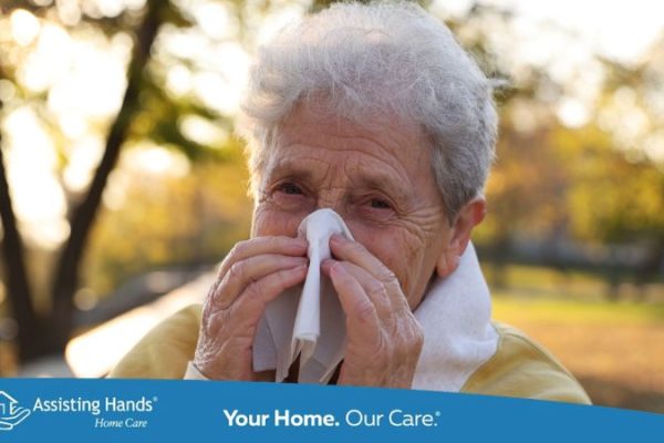 Close-up of an elderly woman outdoors holding a tissue to her nose as she manages a nosebleed.