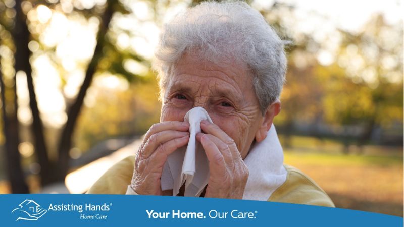 Close-up of an elderly woman outdoors holding a tissue to her nose as she manages a nosebleed.