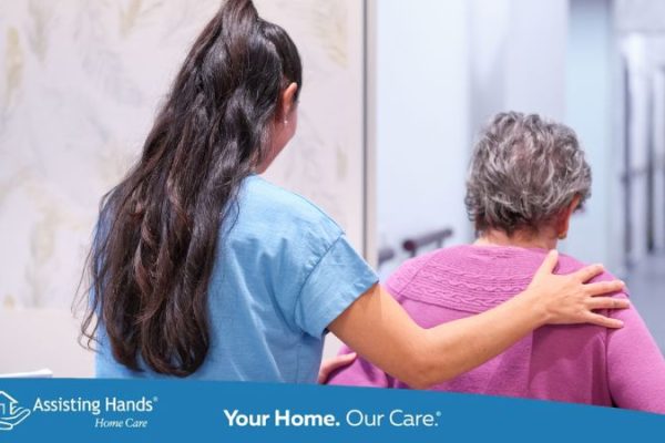 caregiver assisting senior woman with walking
