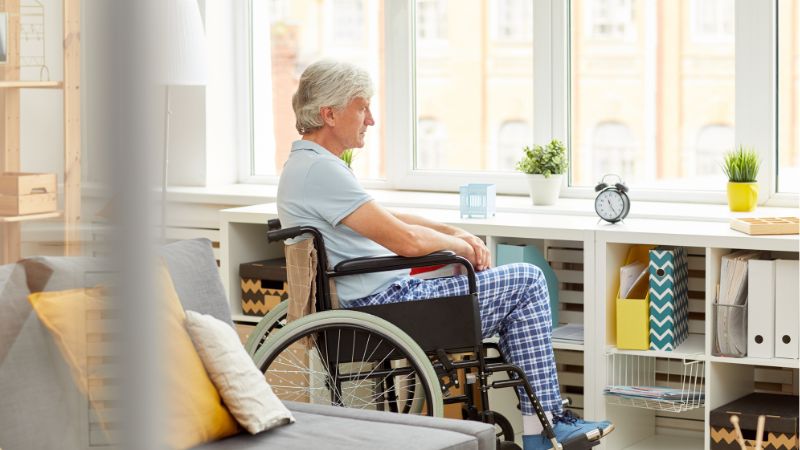 Senior patient sitting in wheelchair and managing all care by himself