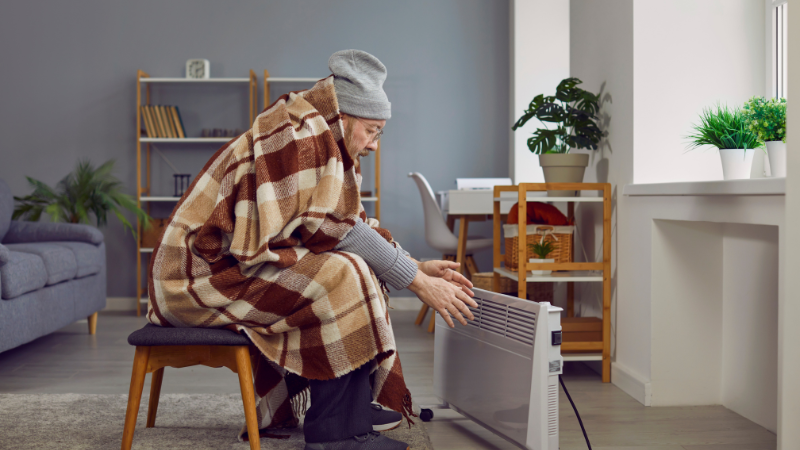 Elderly Man Wrapped in Plaid Feeling Cold at Home