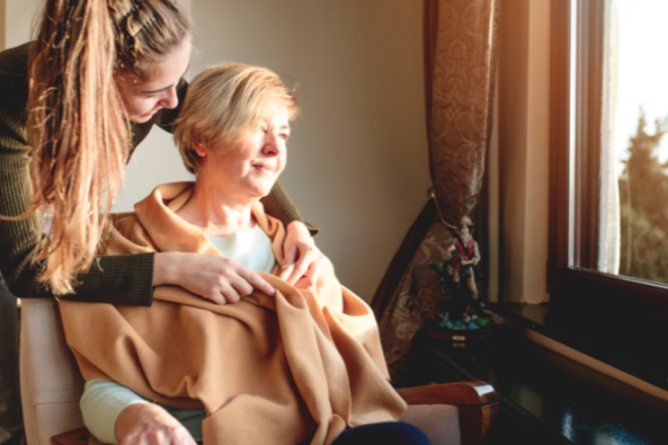 Young family caregiver providing care to elderly woman