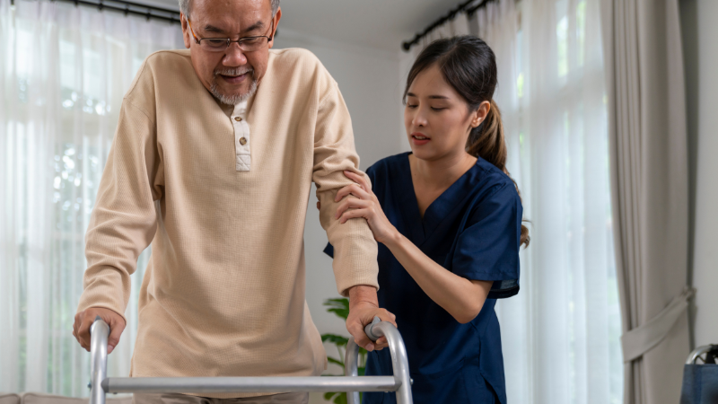 Caregiver assisting an elderly man with mobility