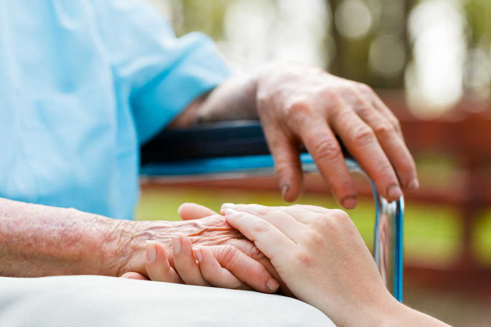 Elderly hands being held by young hands