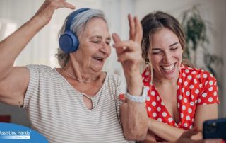 Caregiver and a senior woman smiling while listening to music