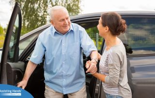 A caregiver helps a senior carefully get out of the care, representing the safety that those who work in home care should strive for.