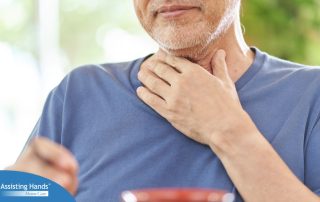 An older adult holds his throat representing dysphagia which can affect senior health.