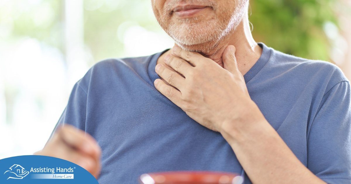 An older adult holds his throat representing dysphagia which can affect senior health.