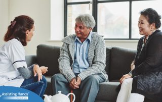 A caregiver talks with an elderly couple representing the kind of communication that professional caregivers need to have to anticipate client needs.