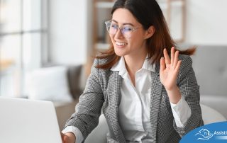 A well-dressed woman smiles and says hi on a videoconference, representing a candidate who is well-prepared for a caregiver interview.