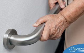 An older adult uses a grab bar representing one of the home modifications that is helpful for fall prevention for elderly adults.