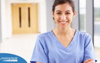 A woman in scrubs smiles, representing the good results that can come when caregivers branch out to become CNAs.
