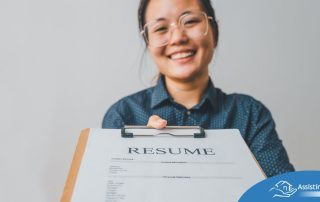 A woman happily hands in a resume, representing a successfully written caregiver resume.