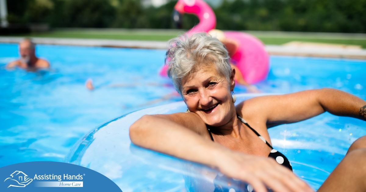 Senior woman in swimming pool outdoors in backyard enjoying summer.