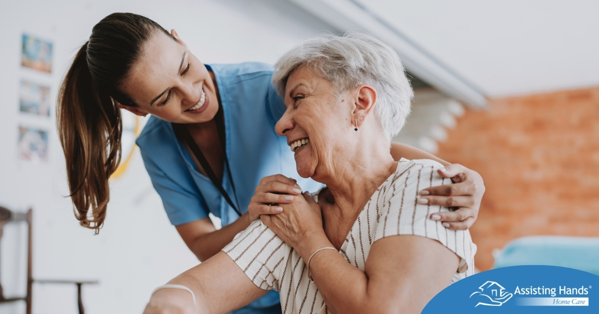A female caregiver helping an older woman with stroke recovery at home.