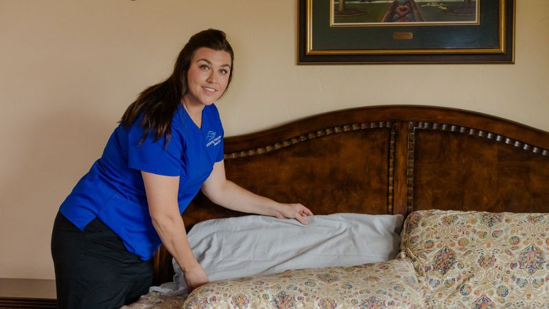 Overnight caregiver adjusting pillow for senior woman
