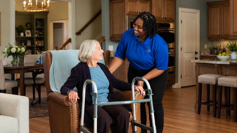 Assisting Hands Caregiver Taking Care of Senior Woman Who Had Knee Surgery