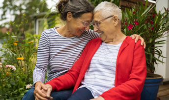 Senior woman with caregiver in the garden