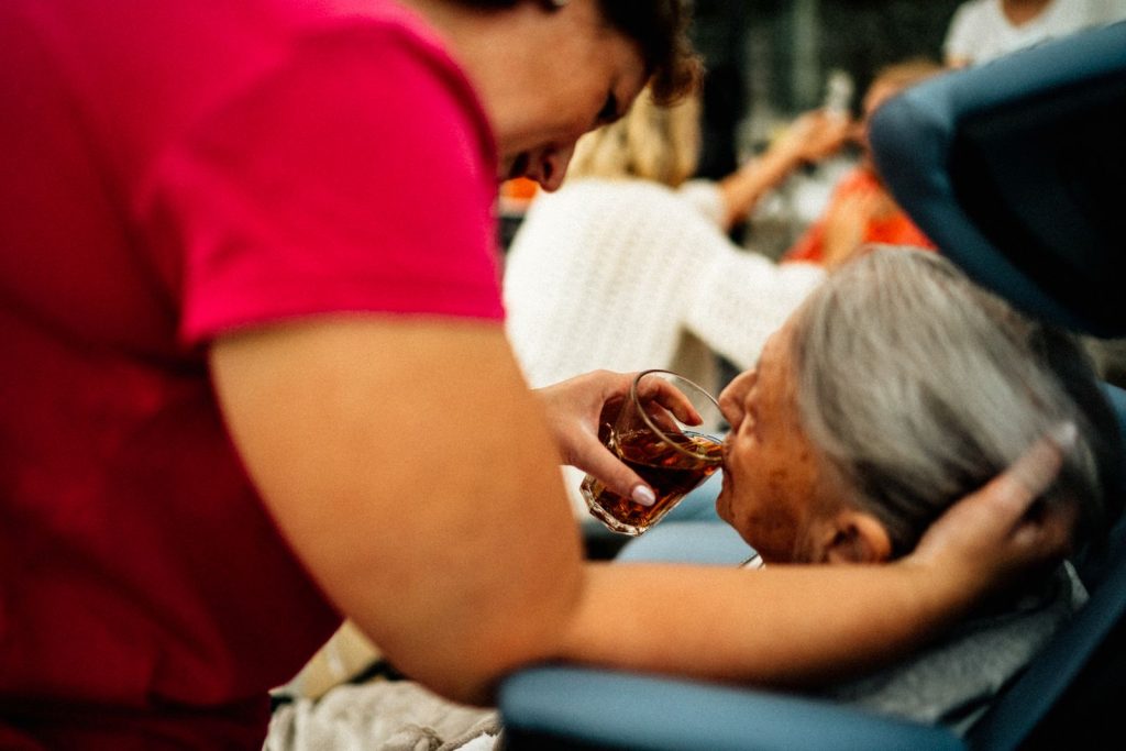 Caregiver offering a cup of tea to a senior woman at home