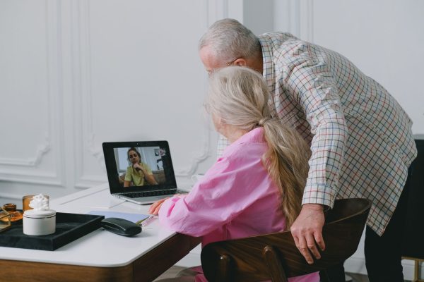 Older couple on a video call with family using a laptop at home