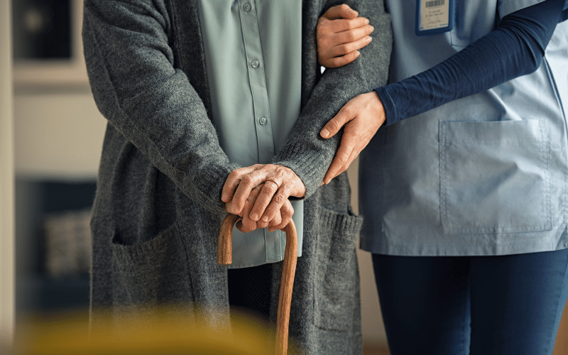 Nurse Assisting Senior with Walking Cane