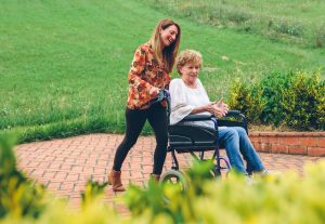 Woman carrying her mother in a wheelchair